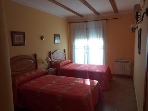 a hotel room with two beds and a window at Apartamentos Cuesta de la Cruz in Caravaca de la Cruz