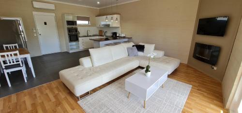 a living room with a white couch and a table at Comfort Inn & Suites King Avenue in Sale
