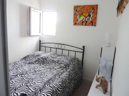- une chambre avec un lit à motifs zébrés dans l'établissement Appartement en Rez-de-Jardin Proche Plage avec Terrasse et Confort Moderne - FR-1-387-54, à Marseillan