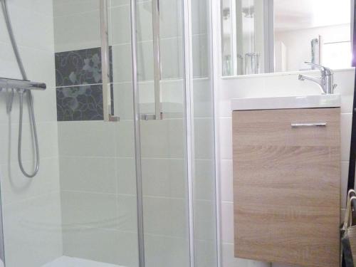 une salle de bain avec douche et lavabo dans l'établissement Appartement en Rez-de-Jardin Proche Plage avec Terrasse et Confort Moderne - FR-1-387-54, à Marseillan