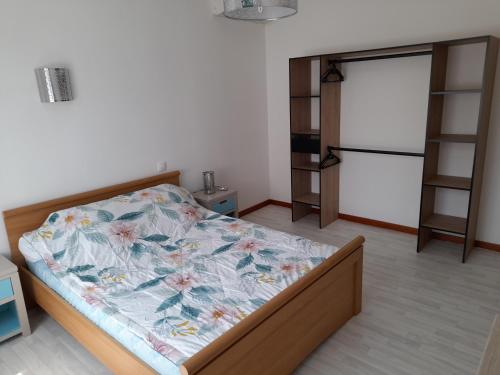 - une chambre avec un lit doté d'une couette à fleurs dans l'établissement Appartement aux portes de l ardèche en cevennes, à Saint-Ambroix