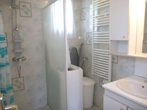 une petite salle de bain avec toilettes et lavabo dans l'établissement Maison avec Piscine, Tennis, Pétanque, Parking et Proche Plage - FR-1-387-171, à Marseillan