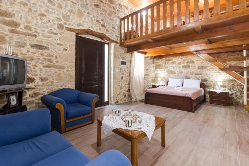 ein Wohnzimmer mit einem Bett, einem Sofa und einem TV in der Unterkunft Villa Margarita's farm, private pool in Maláthiros