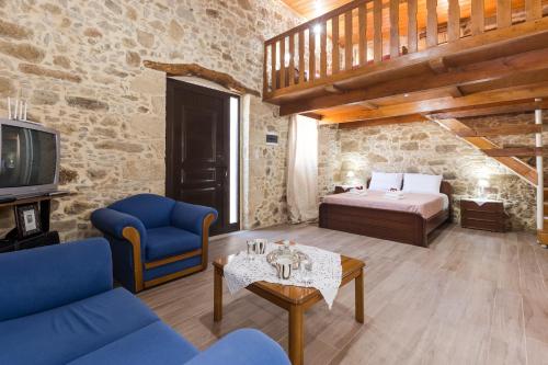 a living room with a bed and a couch and a tv at Villa Margarita's farm, private pool in Maláthiros