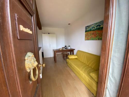 a living room with a yellow couch and a table at Agriturismo TERRANERA in Scansano