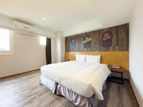 a hotel room with a large bed and a wall with baseball signs at Roaders Hotel Hualien Dongda in Hualien City