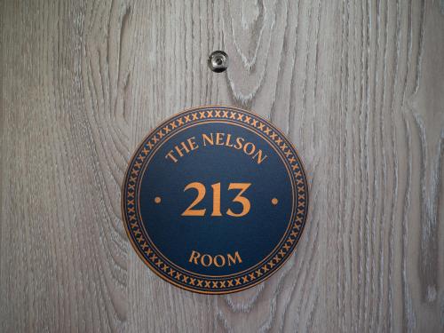 a plaque on a wooden wall with the nelson room at The Merchant's House, BW Signature Collection in Salisbury