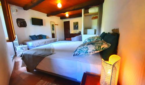 - une chambre avec un grand lit blanc et un canapé dans l'établissement Mas de Boissière - Chambres d'hôtes avec piscine et jacuzzi, à Cros