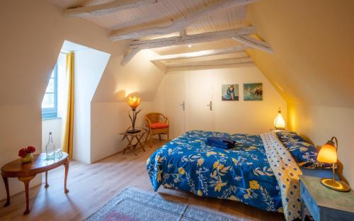 um quarto com uma cama king-size e uma mesa em La Maison Magique em Saint-Chamassy