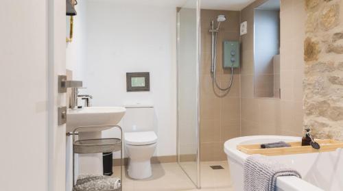 a bathroom with a shower and a toilet and a sink at Hillside Haven, panoramic views Nr Bakewell in Great Rowsley