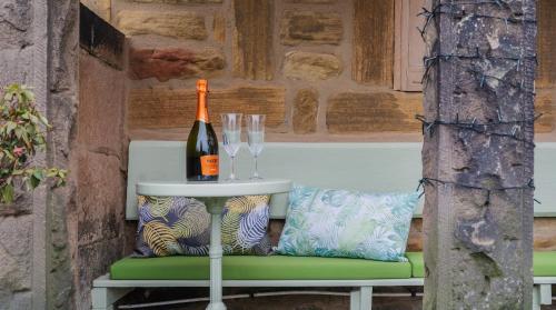 a table with glasses and a bottle of wine at Hillside Haven, panoramic views Nr Bakewell in Great Rowsley