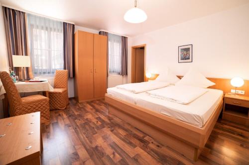 ein Hotelzimmer mit einem Bett und einem Schreibtisch in der Unterkunft Akzent Hotel Schranne in Rothenburg ob der Tauber