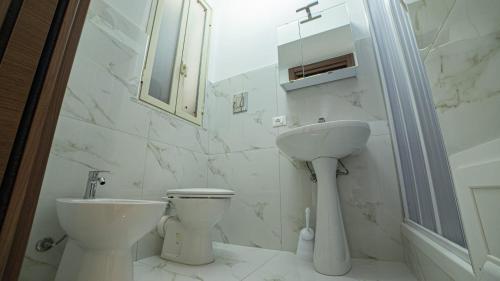 La salle de bains blanche est pourvue de toilettes et d'un lavabo. dans l'établissement Le Case del Porticciolo, à Isola delle Femmine