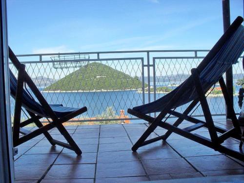 a pair of chairs sitting on a balcony looking at the water at Apartment Bella Vista in Prožura