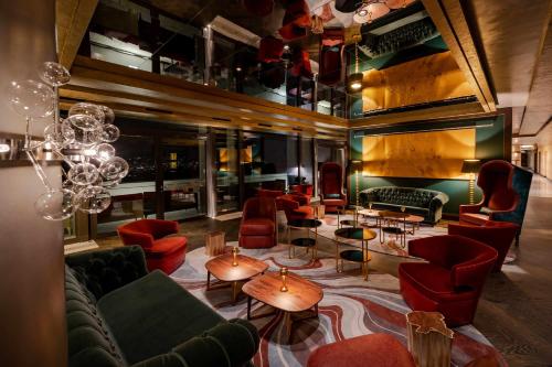a lobby with couches and tables and a chandelier at FIVE Zurich - Luxury City Resort in Zürich
