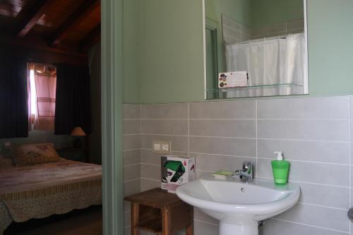 ein Bad mit einem Waschbecken, einem Spiegel und einem Bett in der Unterkunft Casa Rural Osante in Labastida