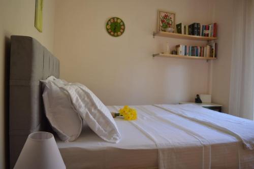 a bed with white pillows and a yellow flower on it at Villa Elm in Pouládes