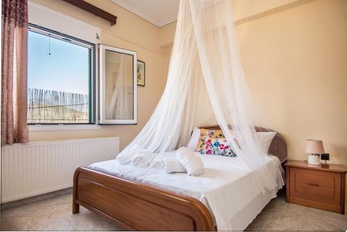 a bedroom with a bed with a mosquito net at STEFANOS HOUSE in Argostoli