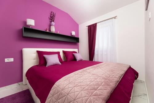 a bedroom with purple walls and a large bed at App Kokotić in Čižići