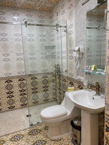 a bathroom with a toilet and a shower and a sink at Shohnishin Boutique in Bukhara