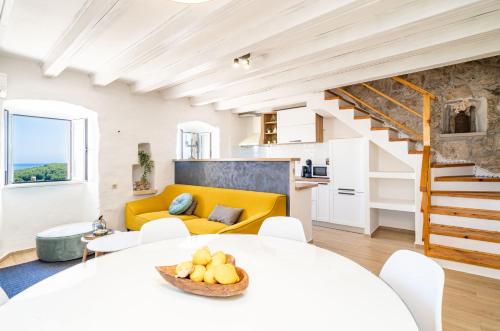 a living room with a white table and a yellow couch at House Abatros in Babino Polje