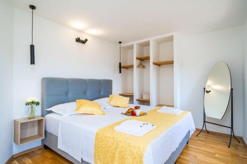 a bedroom with a bed with a blue headboard and a mirror at House Abatros in Babino Polje