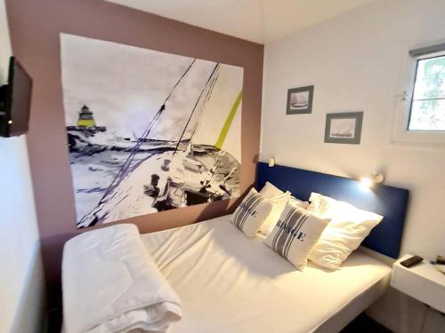 um quarto com uma cama com um quadro na parede em Appartement Six-Fours-les-Plages, 2 pièces, 4 personnes - FR-1-316-274 em Six-Fours-les-Plages