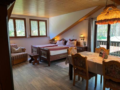 a bedroom with a bed and a table in a room at Schwarzwald - Villa Appartments Titisee in Titisee-Neustadt