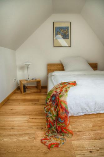 a bedroom with a white bed and a wooden floor at Apartment am Schlosshof in Besigheim