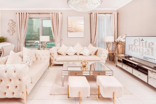 Una sala de estar con muebles blancos y un televisor. en Elite Royal Apartment - Full Burj Khalifa & Fountain View - Signature - 2 bedrooms & 1 open bedroom without partition, en Dubái