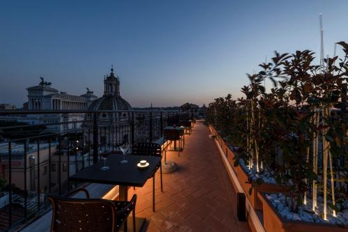 a row of tables and chairs on a balcony at H10 Palazzo Galla in Rome