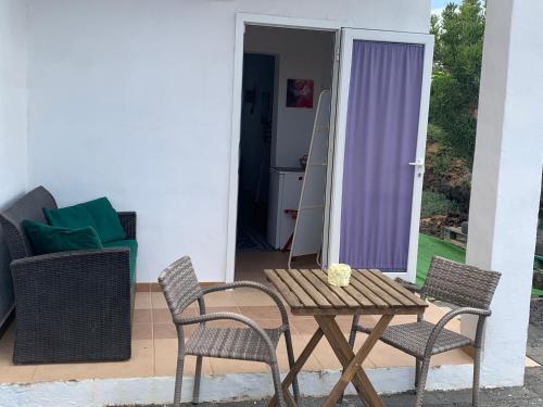 eine Terrasse mit einem Tisch und 2 Stühlen in der Unterkunft joy in Lajares