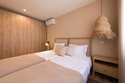 a bedroom with two beds and a basket at Oliva Welcoming Apartments in Proença-a-Nova