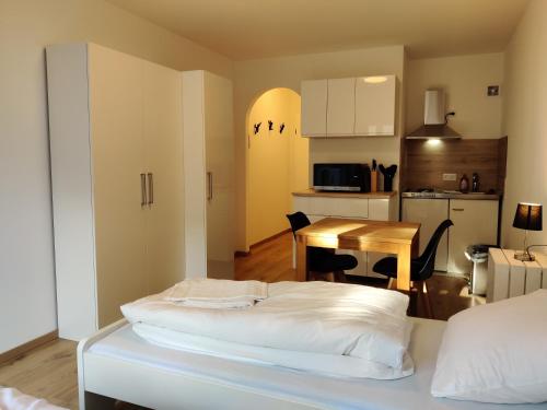 a bedroom with a bed and a kitchen with a table at Schicke Wohnungen in Stadtnähe in Würzburg