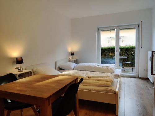 um quarto com uma mesa, uma cama e uma janela em Schicke Wohnung in Stadtnähe em Wurtzburgo