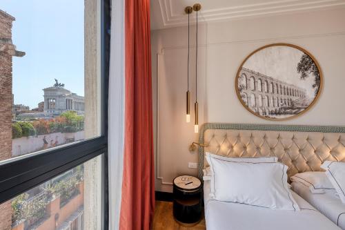 a bedroom with a bed and a large window at H10 Palazzo Galla in Rome
