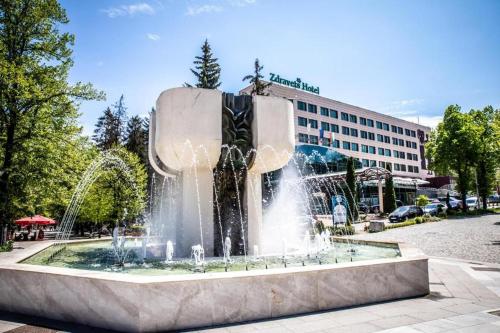 a fountain in front of a building in a city at Zdravets SPA Hotel in Velingrad
