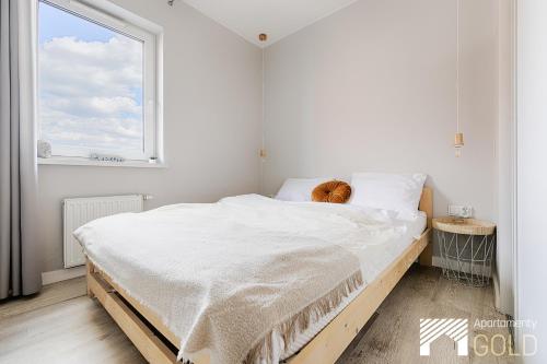 a white bedroom with a large bed and a window at Central Park IV by LookAp in Łódź