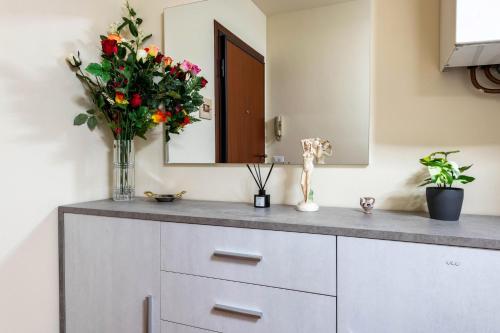a bathroom with a counter with a vase of flowers at Casa Jessika in Gardone Riviera
