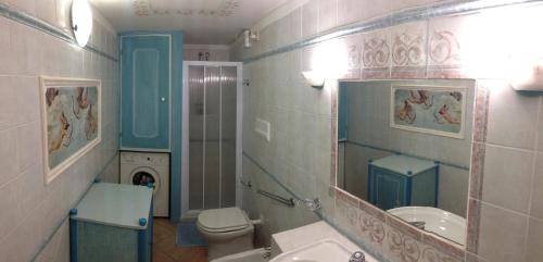a bathroom with a sink and a toilet and a mirror at Sardegna Beach Cala Reale in Santa Marinella