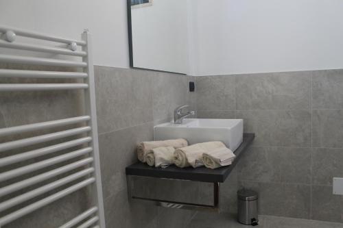 baño con lavabo y toallas en un estante en Studio 60 Holiday, en Galatina