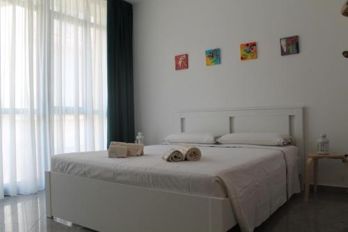 una camera da letto con un letto con due asciugamani sopra di Studio 60 Holiday a Galatina