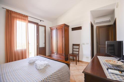 a bedroom with a bed with a table and a tv at Aurora Castelluzzo in Castelluzzo