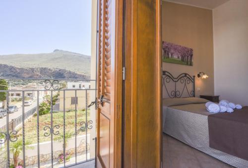 a room with a bed and a balcony with a view at Aurora Castelluzzo in Castelluzzo