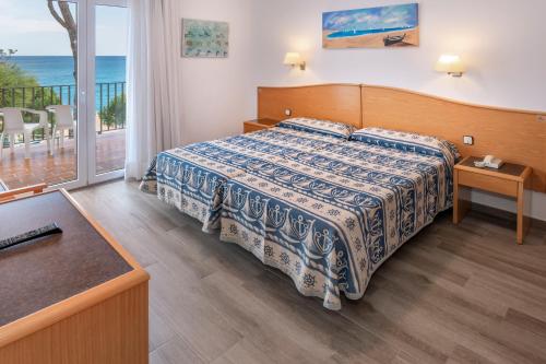1 dormitorio con cama y vistas al océano en GHT Xaloc en Platja  d'Aro