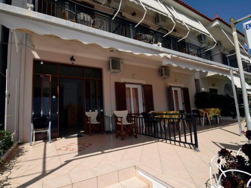 a patio outside of a building with chairs and tables at Mega Apartments in Tiros