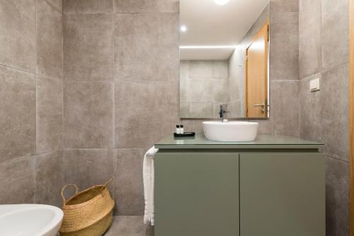 ein Badezimmer mit einem weißen Waschbecken und einem WC in der Unterkunft Oliva Welcoming Apartments in Proença-a-Nova