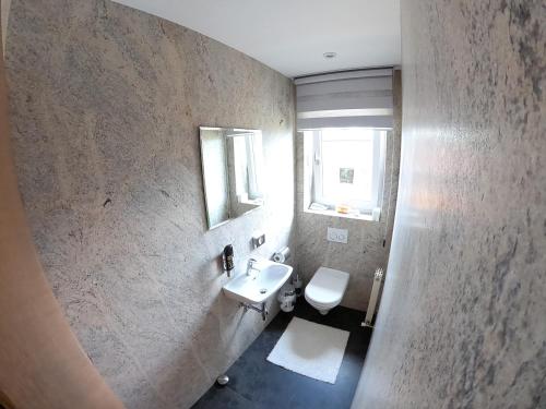 een badkamer met een wastafel, een toilet en een spiegel bij Ferienwohnung Stock in Rinn