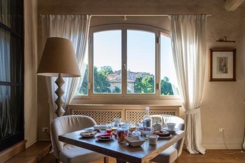 a dining room table with chairs and a window at Il Borro Relais & Châteaux in San Giustino Valdarno
