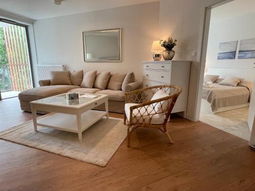 a living room with a couch and a table at PINEA Apartments Pobierowo z niesamowitym widokiem na morze oraz jacuzzi w wybranych apartamentach in Pobierowo